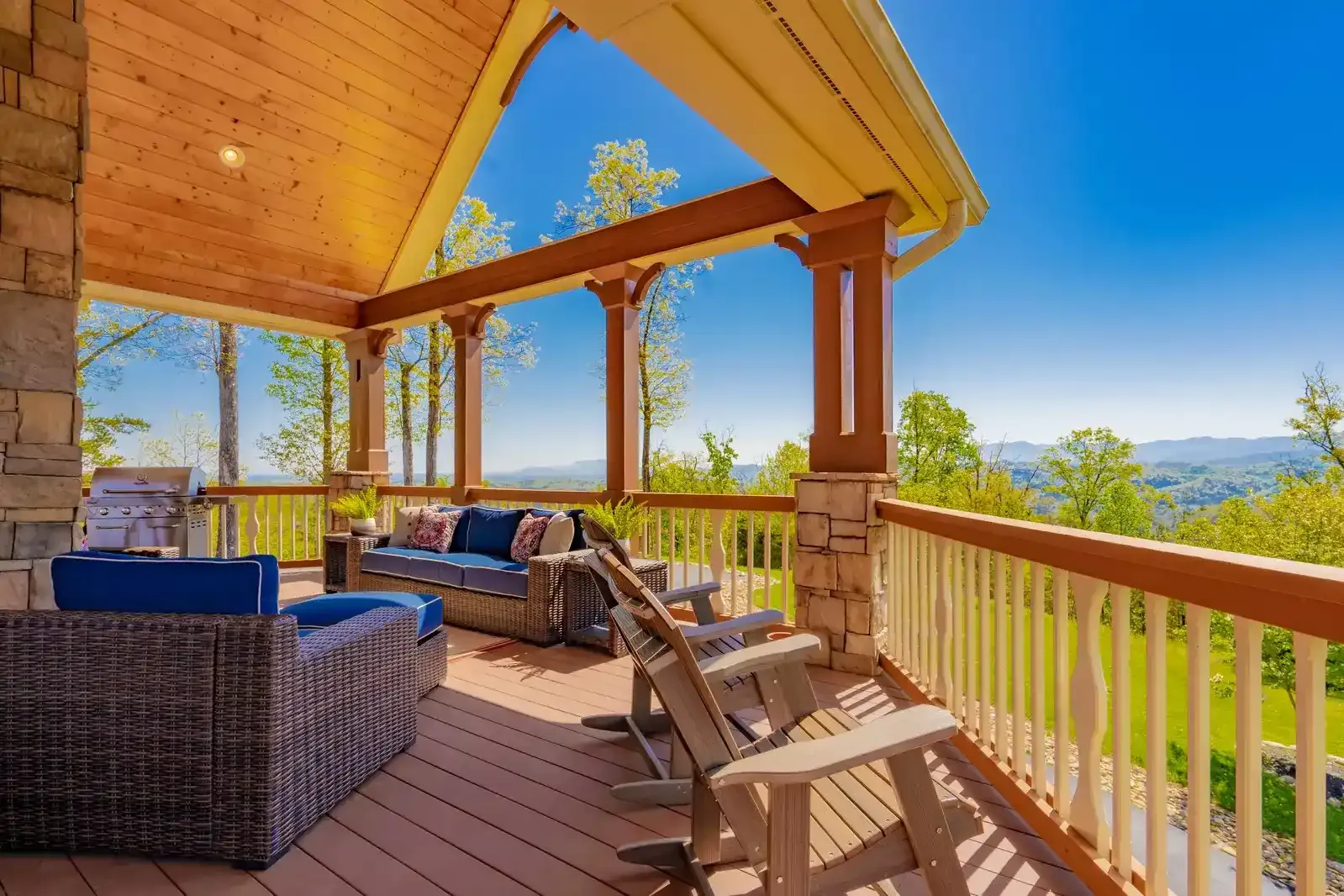 a deck with a couch and chairs and a grill